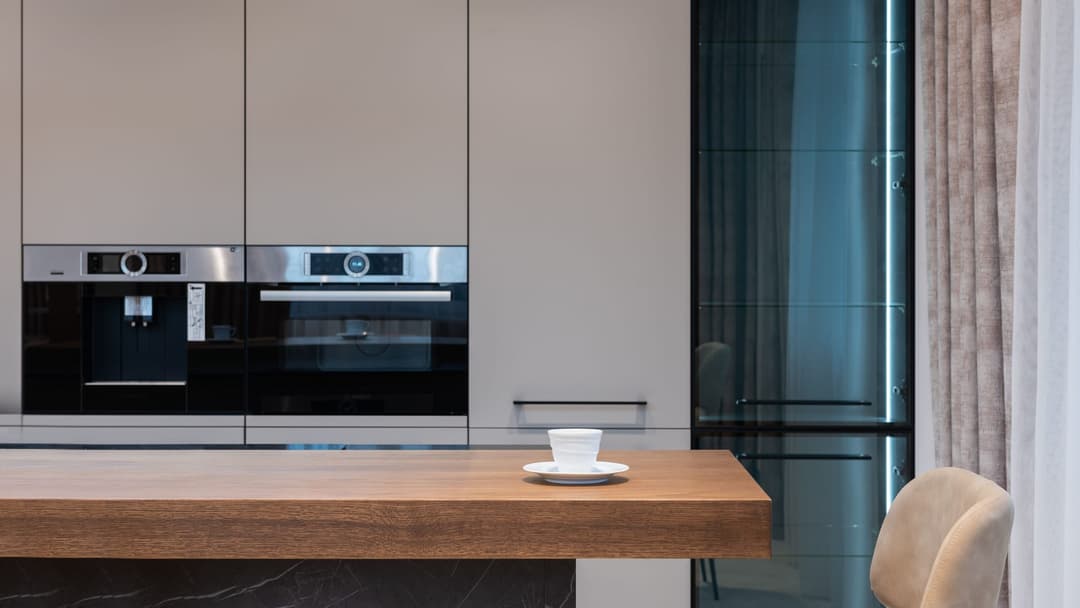 Kitchen worktop in an oak decor with a thick edge and a cup in front of light cabinets