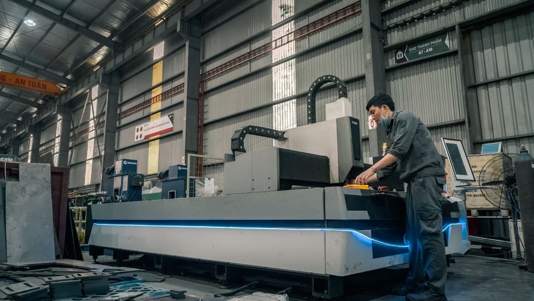 Operator at a CNC machine in a production hall