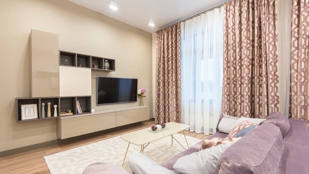 Living room with a TV wall unit: wall-hung cabinets, open shelves and a television on the wall