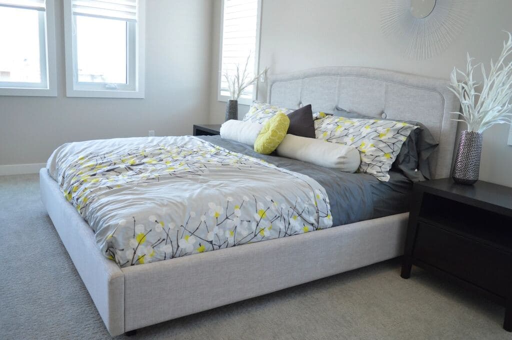 Bedroom with an upholstered bed and a dark nightstand against the wall